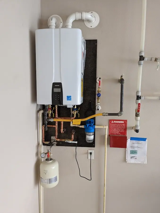 Professional plumber installing copper piping in a Caledonia home